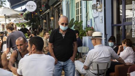 Ein Mann, der eine Schutzmaske in einem überfüllten Restaurant in Jaffa, Israel, am 29. Mai trägt.