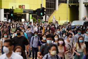 Pedestrians wearing protective masks walk across a road in Hong Kong, China, on July 10.