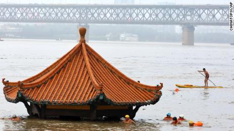 Die Bewohner schwimmen am 8. Juli in Wuhan in der zentralchinesischen Provinz Hubei an einem Pavillon am Flussufer vorbei, der vom überfluteten Jangtse überflutet ist.