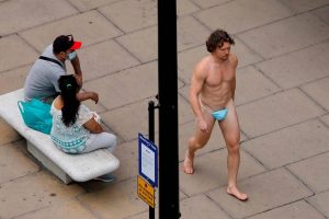 Man covers genitals with Face Mask; walks semi-naked on Oxford Street