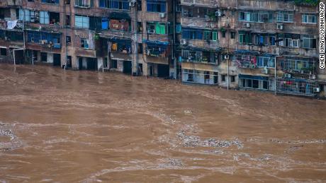 Hochwasser fließt am 1. Juli an einem Wohngebäude in Chongqing im Südwesten Chinas vorbei.