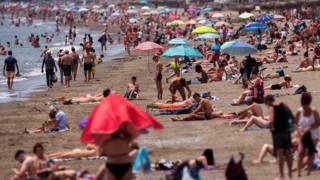 Menschen an einem sonnigen Tag am Strand in Malaga im Juni