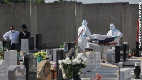 Bestattungsunternehmer tragen am 21. April die Leiche eines Covid-19-Patienten auf einem Friedhof in der zentralisraelischen Stadt Rehovot.