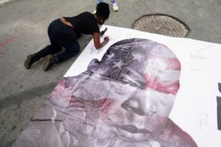 Eine Frau signiert ein Bild des verstorbenen US-Kongressabgeordneten John Lewis
